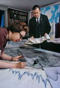 Marie Tharp dibujando mapas y Bruce Heezen con unos papeles en las manos.